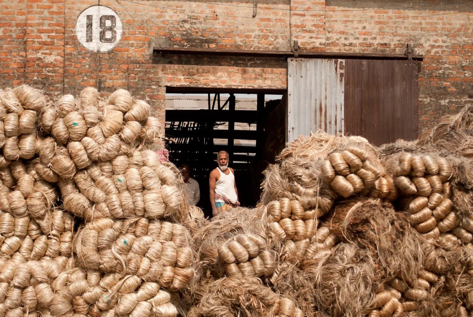 Bundles of raw jute fibre stacked at a jute warehouse